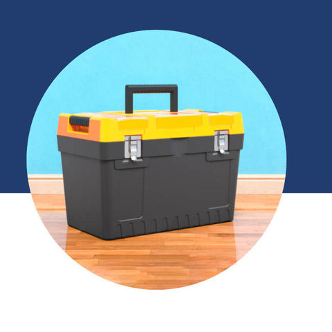 Dark gray toolbox with a yellow lid and orange handle, sitting on a wood floor.
