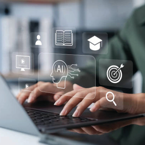 Hands typing on a laptop with floating digital icons including an AI head, graduation cap, book, and target symbol.