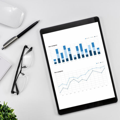 Tablet displaying bar and line charts on a desk, representing data analysis and reporting to track student outcomes and retention.