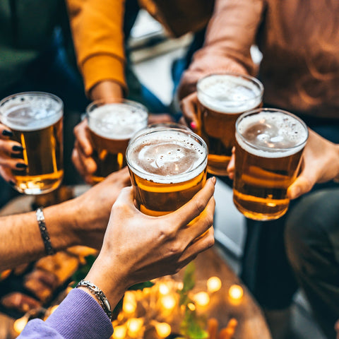 People holding glasses of beer together in a festive setting