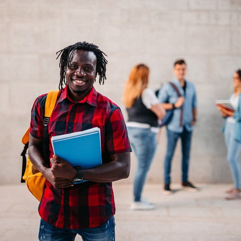 Man holding a blue folder with people in the background