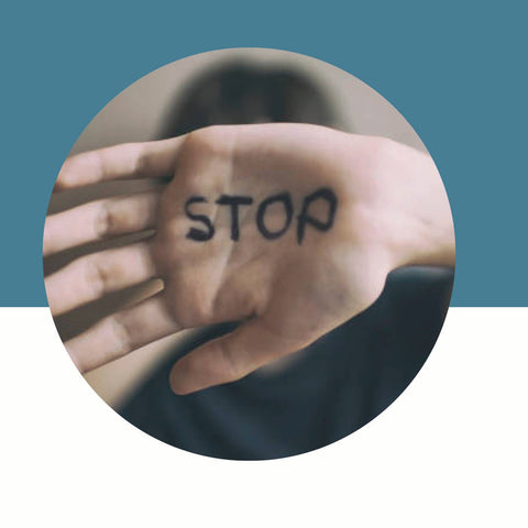 Hand with the word "Stop" written on the palm on a blue and white background.