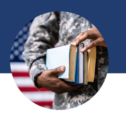 A person in military fatigues holding a stack of books, with an American flag in the background.