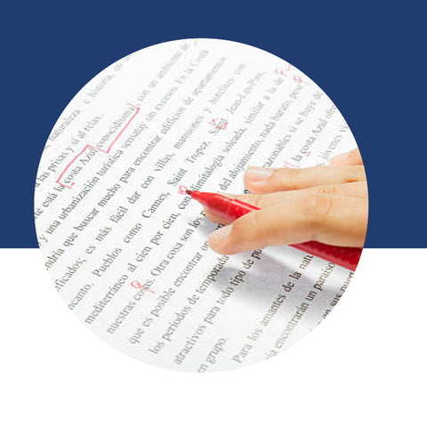 A hand using a red pen to mark corrections on a printed page