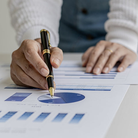 Person analyzing financial charts on a table