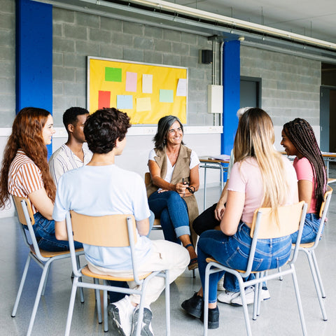 Group of people sitting in a circle in a classroom setting