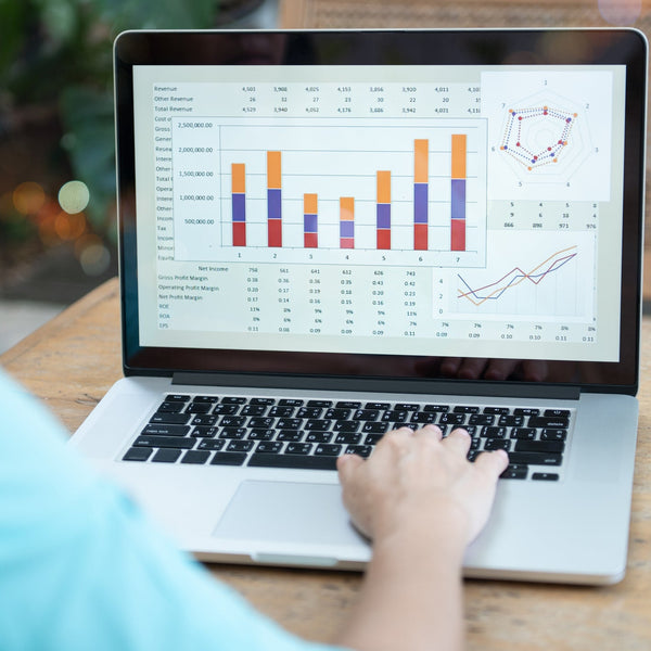 Person using a laptop with financial charts on the screen