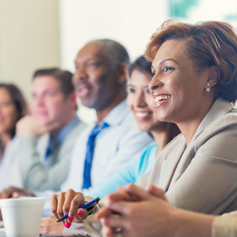 Group of people sitting together, possibly in a meeting or workshop setting.