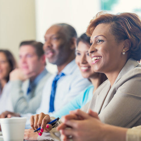 Group of people sitting together, possibly in a meeting or workshop setting.