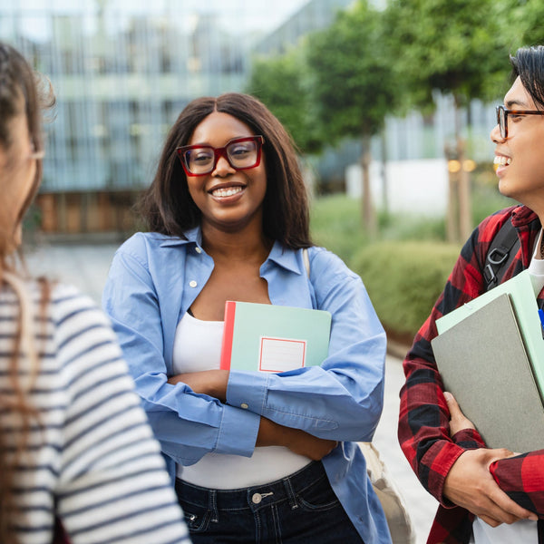 Group of students standing outdoors, engaged in conversation.
