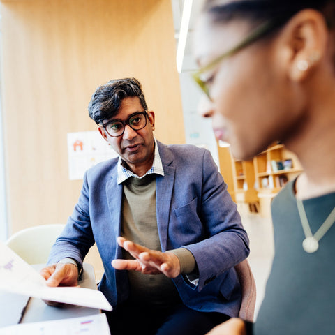 Supervisor and employee engaged in a professional one-on-one discussion while reviewing documents, representing workplace communication and strategies for navigating challenging work relationships.