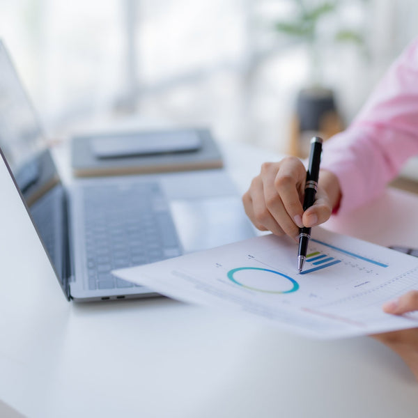 Person analyzing charts on a laptop with a blurred background