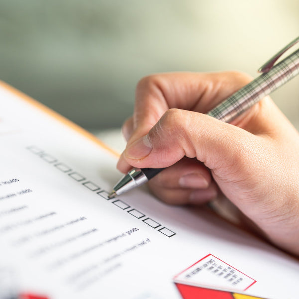 Hand holding a pen over a document with a blurred background