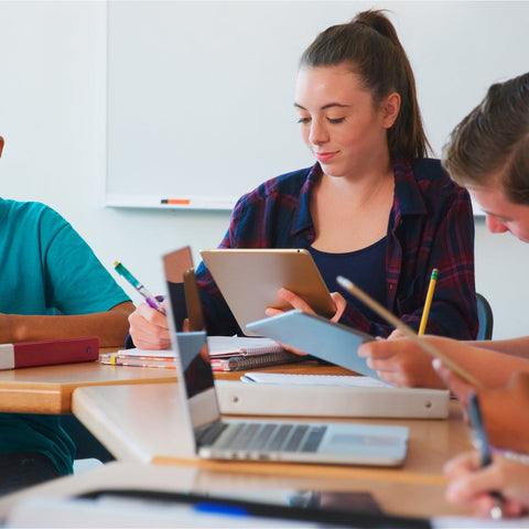 Students in a classroom using tablets and laptops.
