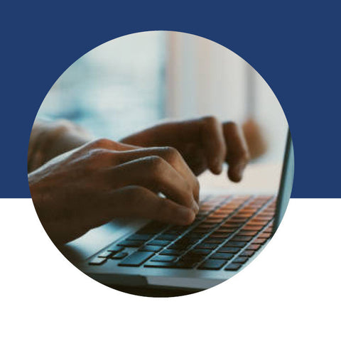 Close-up of hands typing on a laptop keyboard.