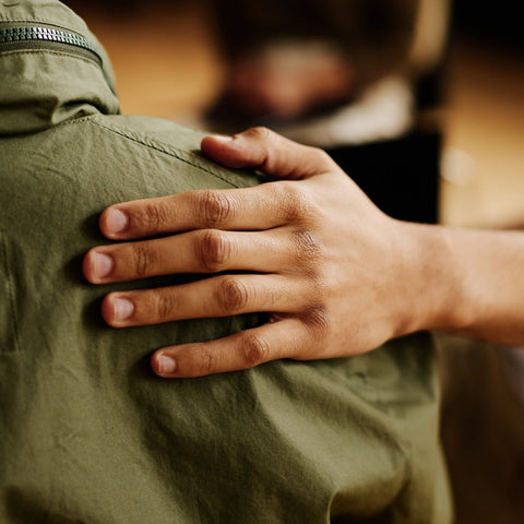 Hand on a green jacket with a blurred background