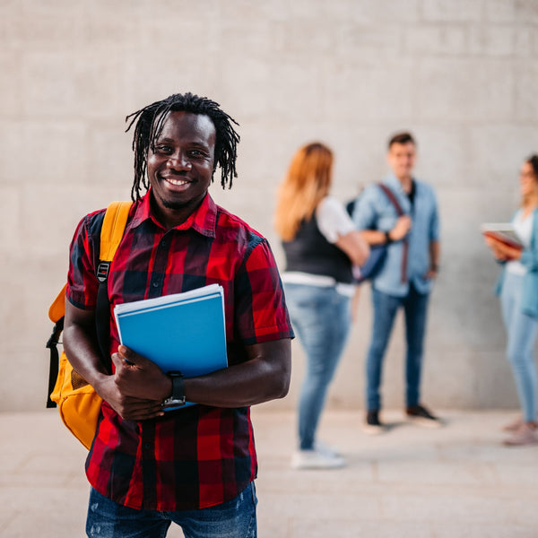 Man holding a blue folder with people in the background