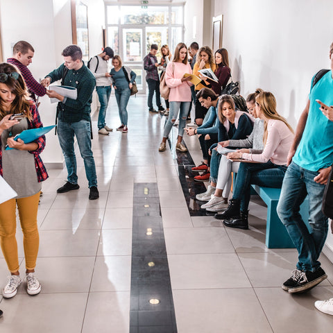 People waiting in line and sitting on benches in a hallway