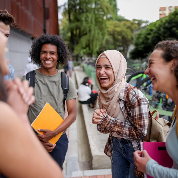 Group of young people laughing together outdoors on a college campus