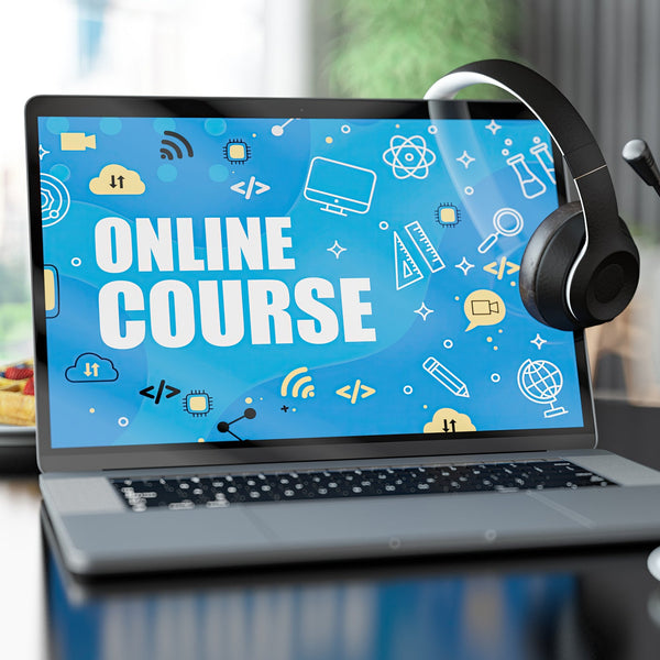 Laptop with 'Online Course' on screen, headphones, and coffee cup on desk