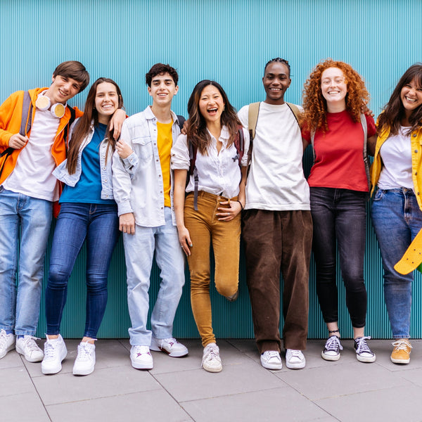 Diverse group of college-aged students standing together and smiling, representing inclusion, confidence, and a supportive learning community.