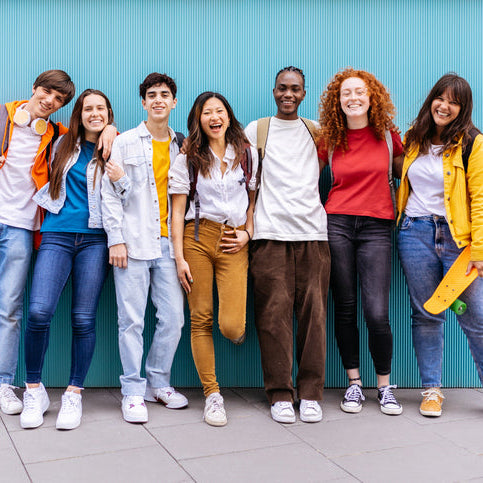 Diverse group of college-aged students standing together and smiling, representing inclusion, confidence, and a supportive learning community.