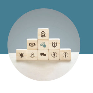 Wooden blocks with icons stacked on a white surface against a blue background