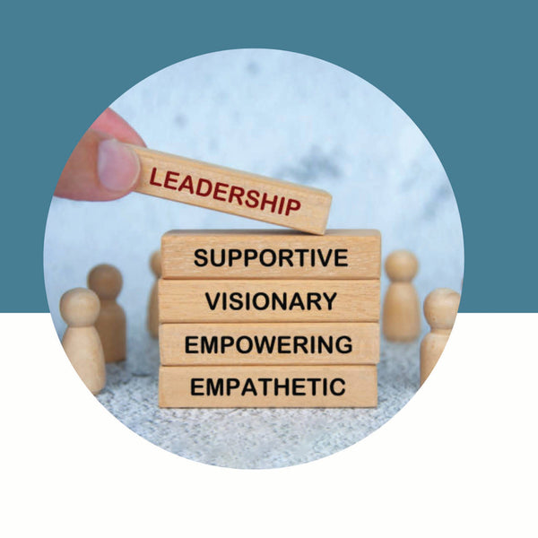 Hand placing a wooden block labeled "Leadership" on a stack of blocks with leadership qualities on a teal and white background.