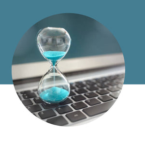 Hourglass with blue sand on a laptop keyboard against a blue background