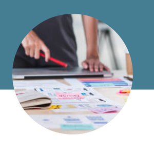 Person using a laptop with a colorful document on a desk, against a blue background