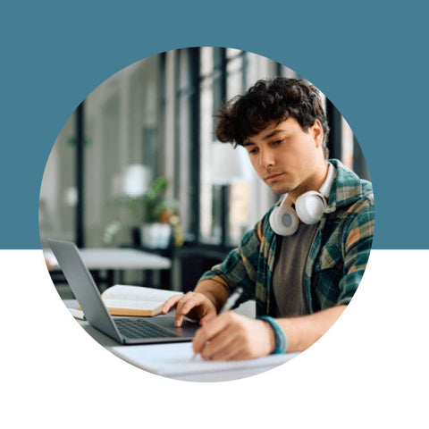 Person using a laptop with a teal background