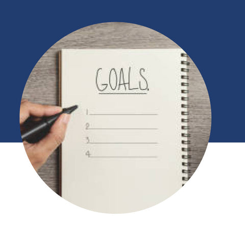 A spiral notebook page with "Goals" written at the top and a numbered list below.
