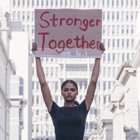Young woman holding a "Stronger Together" sign during a street protest