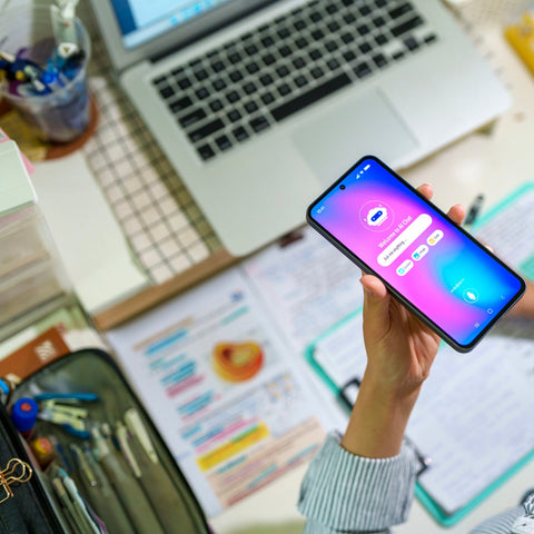 Person holding a smartphone with a colorful screen in an office setting