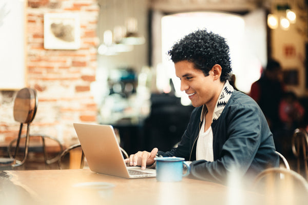 Student working on a laptop in a café.
