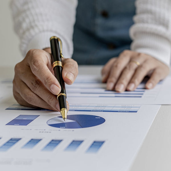 Person analyzing financial charts on a table