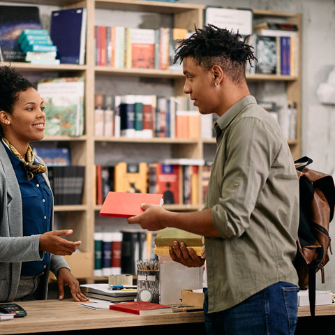 Two people in a bookstore with bookshelves in the background