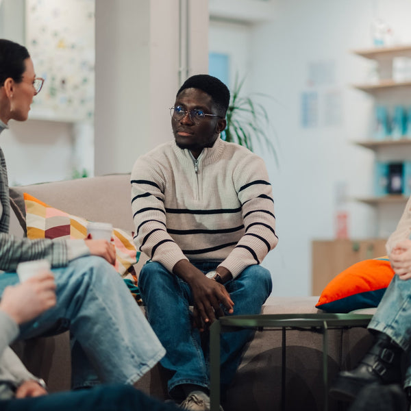 Group of people sitting in a circle in a modern living room setting