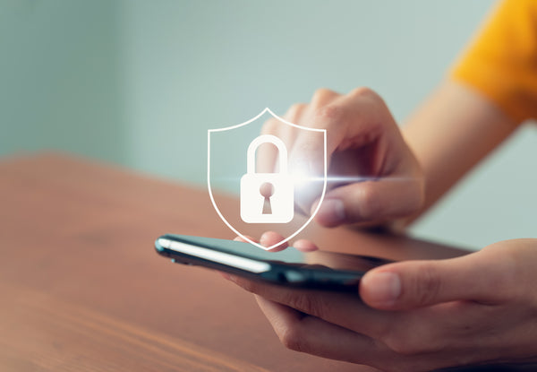 Hand holding a smartphone with a digital lock icon overlay, symbolizing data security.

