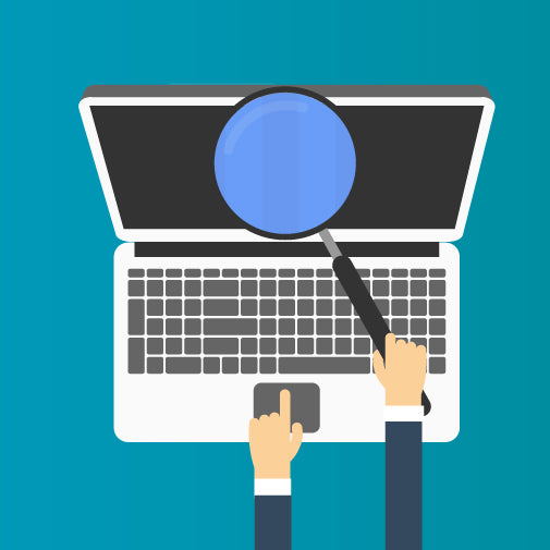 A person holding a magnifying glass over a laptop keyboard, with one finger pointing at the touchpad