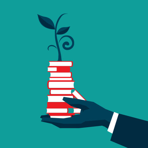 Image of hands holding a stack of books with a plant growing out of the books
