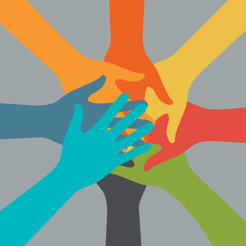 Multi-colored hands on top of each other on a grey background.